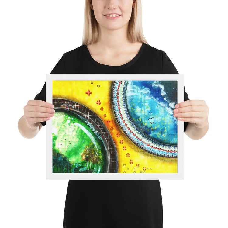 Woman holding framed artwork featuring stylized green and blue planets on yellow background